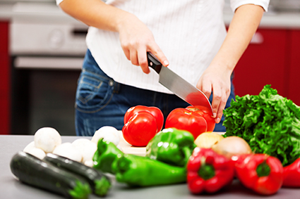 Persona cortando tomates para gazpacho con cuchillo